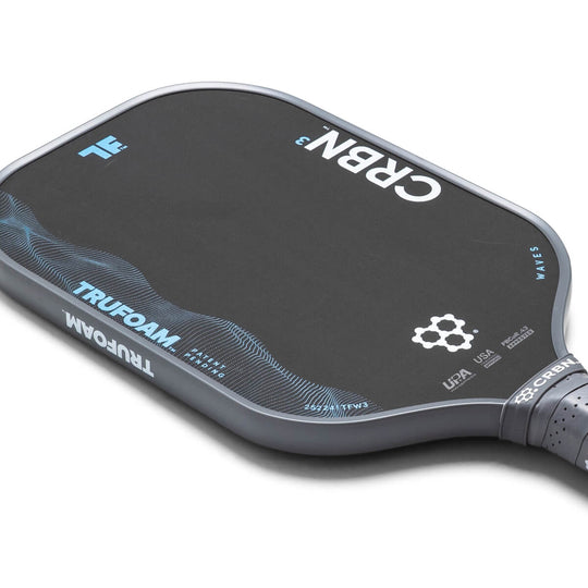 Close-up of a pickleball paddle with branding on a white background