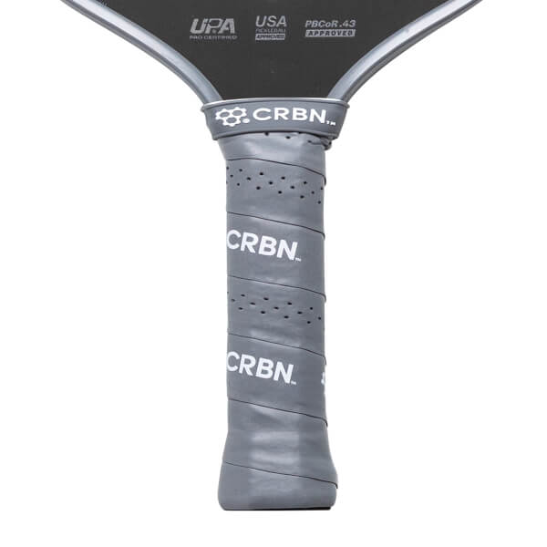 Close-up of a gray pickleball paddle with 'CRBN' branding on a white background