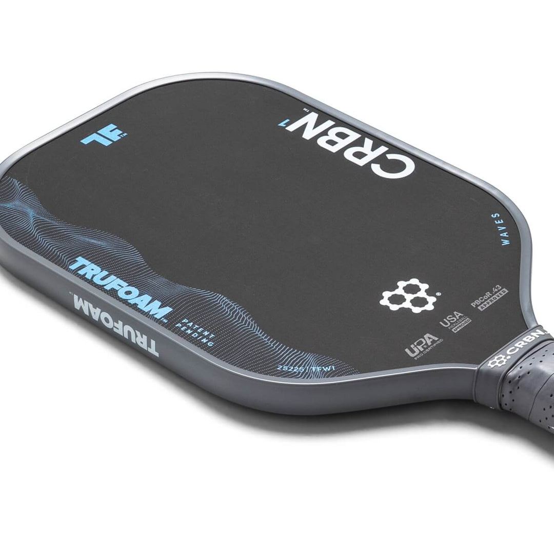 Close-up of a pickleball paddle with visible branding on a white background