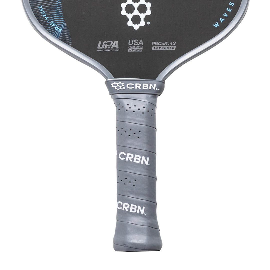 Close-up of a pickleball paddle with CRBN branding on a white background
