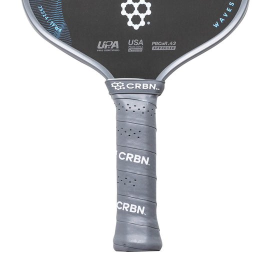 Close-up of a pickleball paddle with CRBN branding on a white background