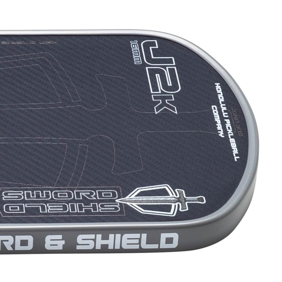 Close-up of a pickleball paddle with branding and text on a white background