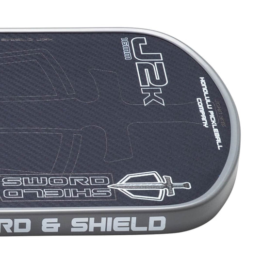Close-up of a pickleball paddle with branding and text on a white background