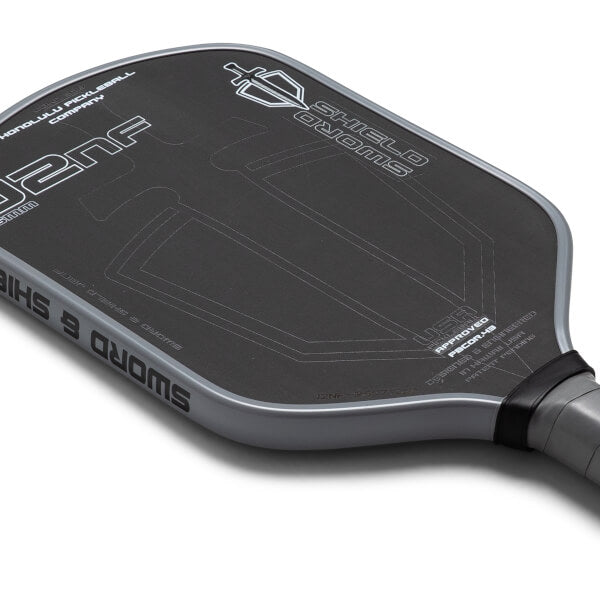 Close-up of a pickleball paddle with branding on a white background